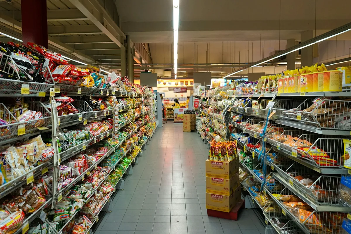 Full-size supermarket with wide aisles, distinct sections and bright modern signage
